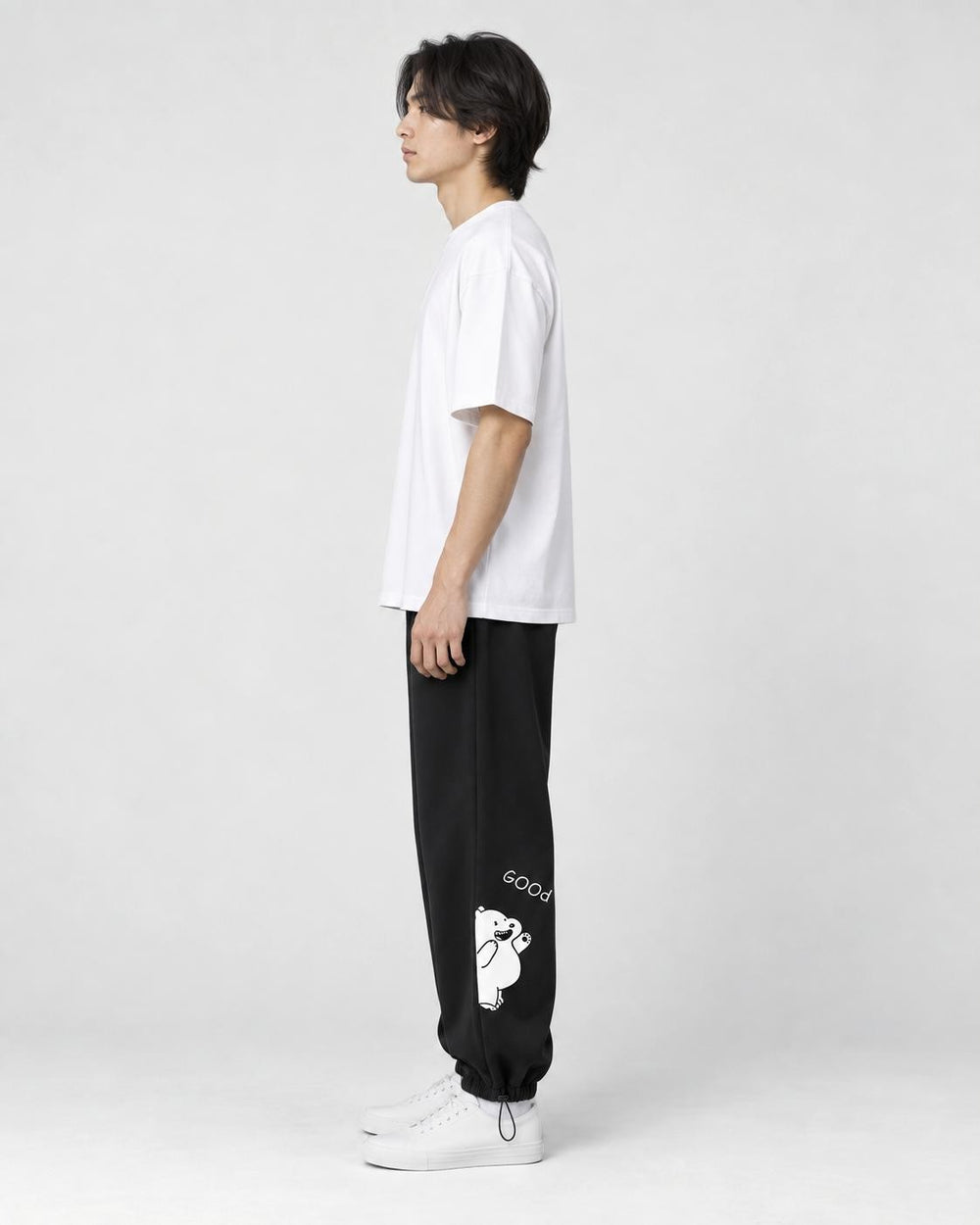 Model seen from the side in the black bear jogger sweatpants with a white tee and white sneakers