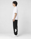 Model seen from the side in the black bear jogger sweatpants with a white tee and white sneakers
