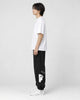 Model seen from the side in the black bear jogger sweatpants with a white tee and white sneakers
