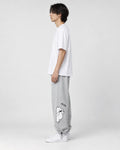 Model seen from the side in the heather gray bear jogger sweatpants with a white tee and white sneakers