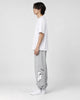 Model seen from the side in the heather gray bear jogger sweatpants with a white tee and white sneakers