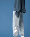 Heather gray jogger sweatpants with a white cartoon bear and the word GOOD on the lower leg, side view