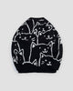 Back of the black cat face knit sweater, with the crowd of white line-drawn cats