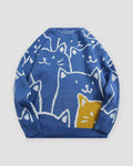 Blue knit sweater covered in white line-drawn cat faces with one yellow cat at the lower right, front view