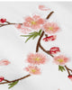 Close-up of the embroidered cherry-blossom sprig on white fabric