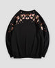Black crew-neck sweatshirt laid flat, back with blossom branches across the shoulders