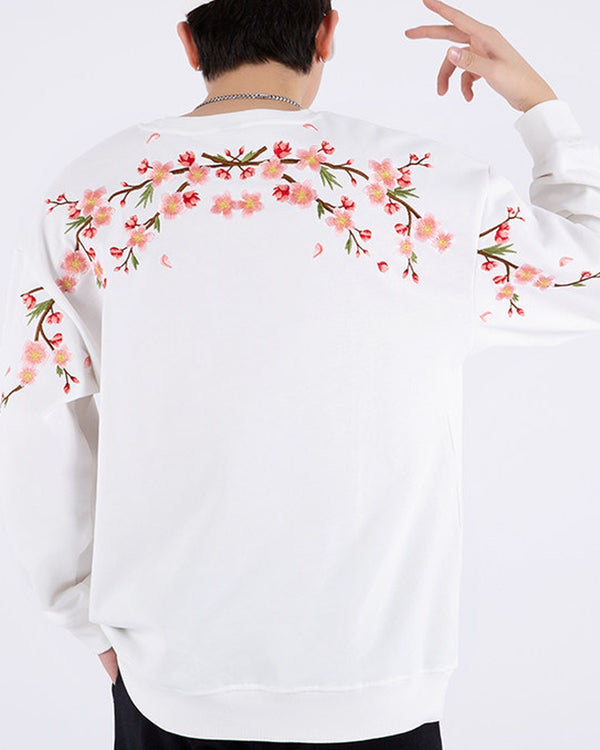 White loose sweatshirt, back view with pink cherry-blossom branches embroidered across the shoulders
