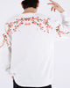 White loose sweatshirt, back view with pink cherry-blossom branches embroidered across the shoulders