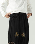 Close-up of the wide sash knotted at the waist, with gold wave embroidery on the two hanging ends