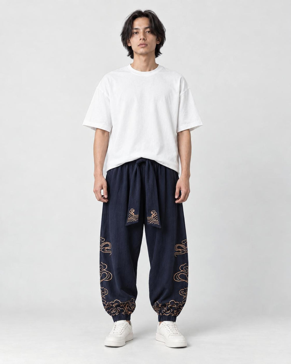 Model wearing the navy cloud-embroidered lantern pants with a white tee and white sneakers, front view