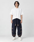 Model wearing the navy cloud-embroidered lantern pants with a white tee and white sneakers, front view