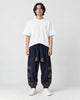 Model wearing the navy cloud-embroidered lantern pants with a white tee and white sneakers, front view