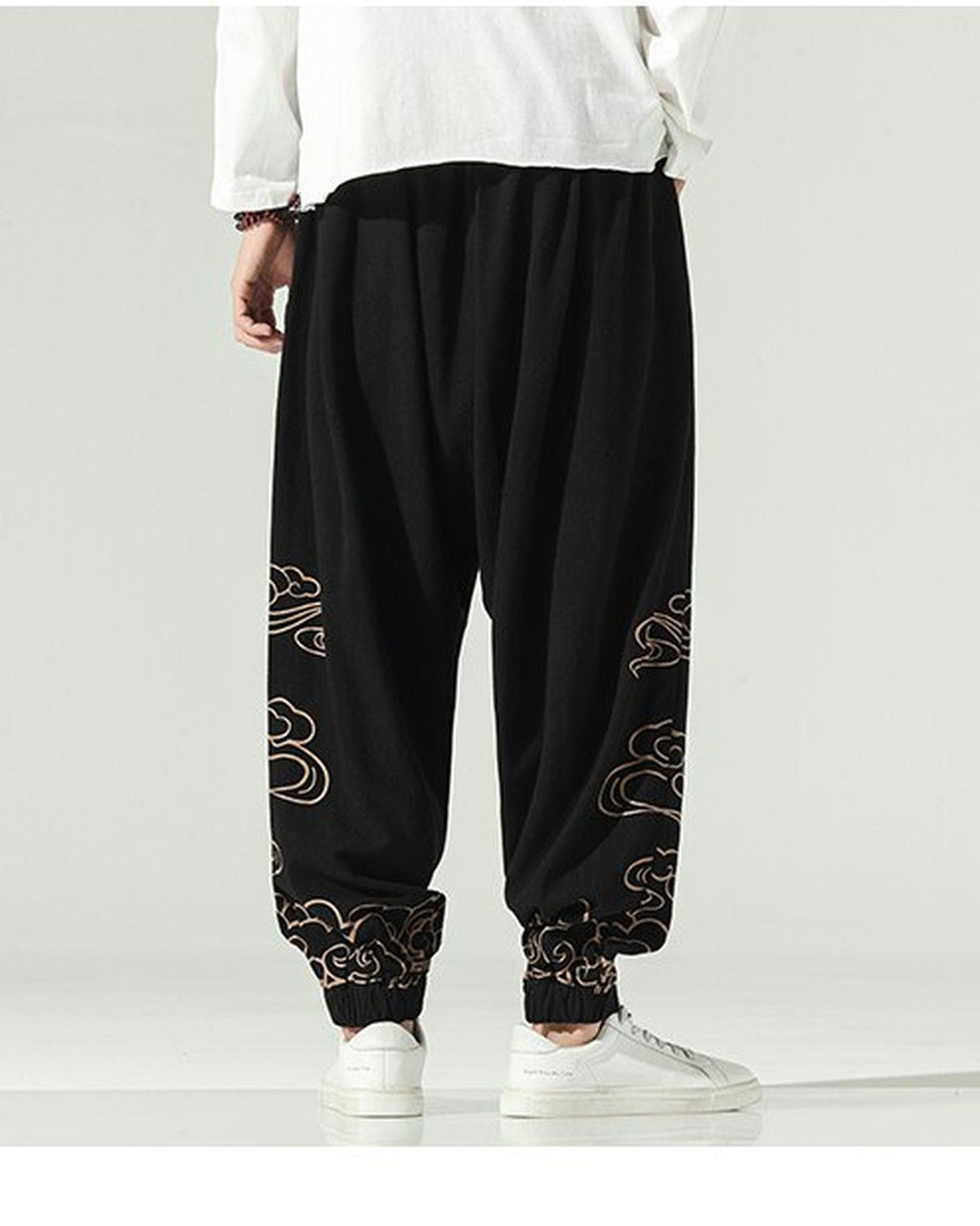 Black lantern pants with gold cloud embroidery on the lower legs and a knotted sash, worn with a white shirt
