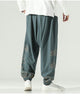 Gray green lantern pants with gold cloud embroidery on the lower legs and a knotted sash, worn with a white shirt