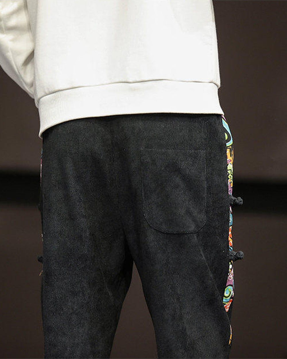 Back of the black corduroy joggers showing the patch pocket and the side panel with frog-button knots