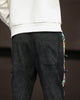 Back of the black corduroy joggers showing the patch pocket and the side panel with frog-button knots