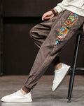 Side view of the brown corduroy joggers showing the long printed panel with frog-button knots on the outer seam