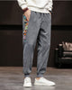 Slate gray corduroy joggers with a printed side panel and ribbed cuffs, worn with a white sweatshirt and white sneakers