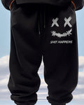 Black jogger pants with a white smiley print on the thigh, worn standing, waist to shin