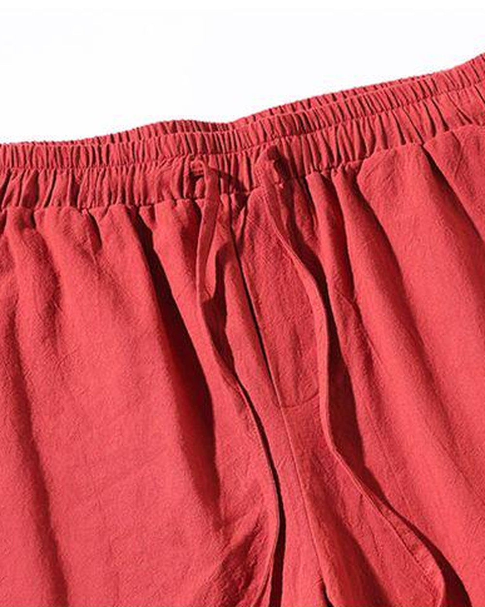 Close-up of the elastic waist and the drawcord on the red jogger pants