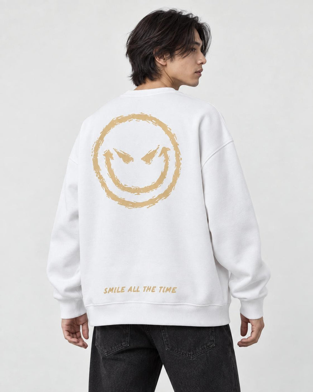 Model seen from behind at an angle in the white crewneck sweatshirt with a large gold devil smiley