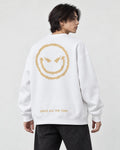 Model seen from behind at an angle in the white crewneck sweatshirt with a large gold devil smiley