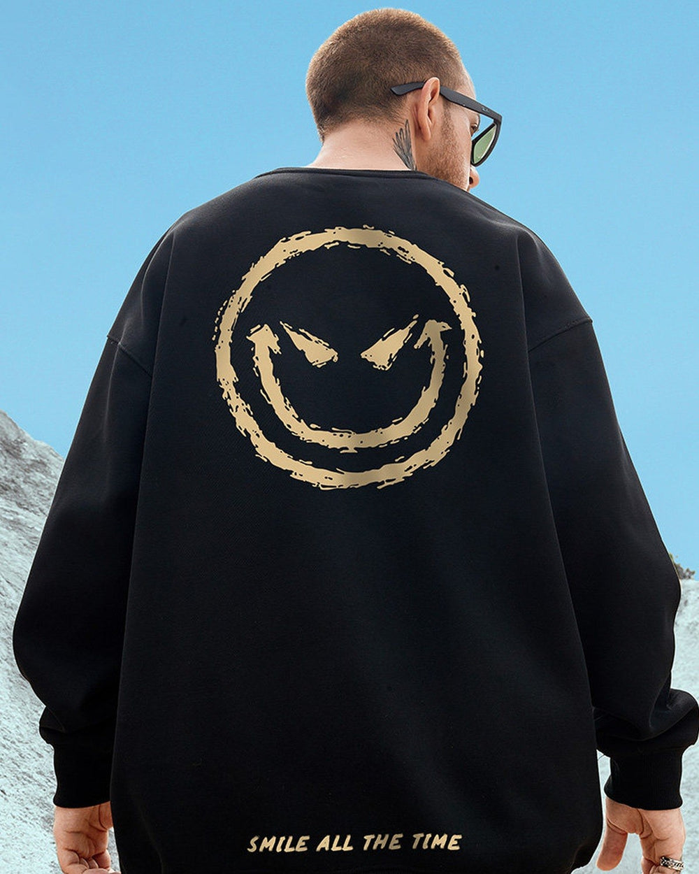 Black crewneck sweatshirt seen from behind with a huge gold devil smiley and SMILE ALL THE TIME near the hem