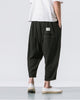 Back of the black crinkled harem pants showing the patch pocket with a small woven label