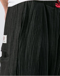 Close-up of the red drawcord and the crinkled weave on the black harem pants