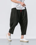 Black crinkled harem pants with a red drawcord and rolled cuffs, worn with a white tee and white slip-on shoes