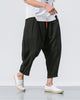 Black crinkled harem pants with a red drawcord and rolled cuffs, worn with a white tee and white slip-on shoes