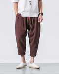 Coffee brown crinkled harem pants from the side, showing the tapered leg and the rolled cuff