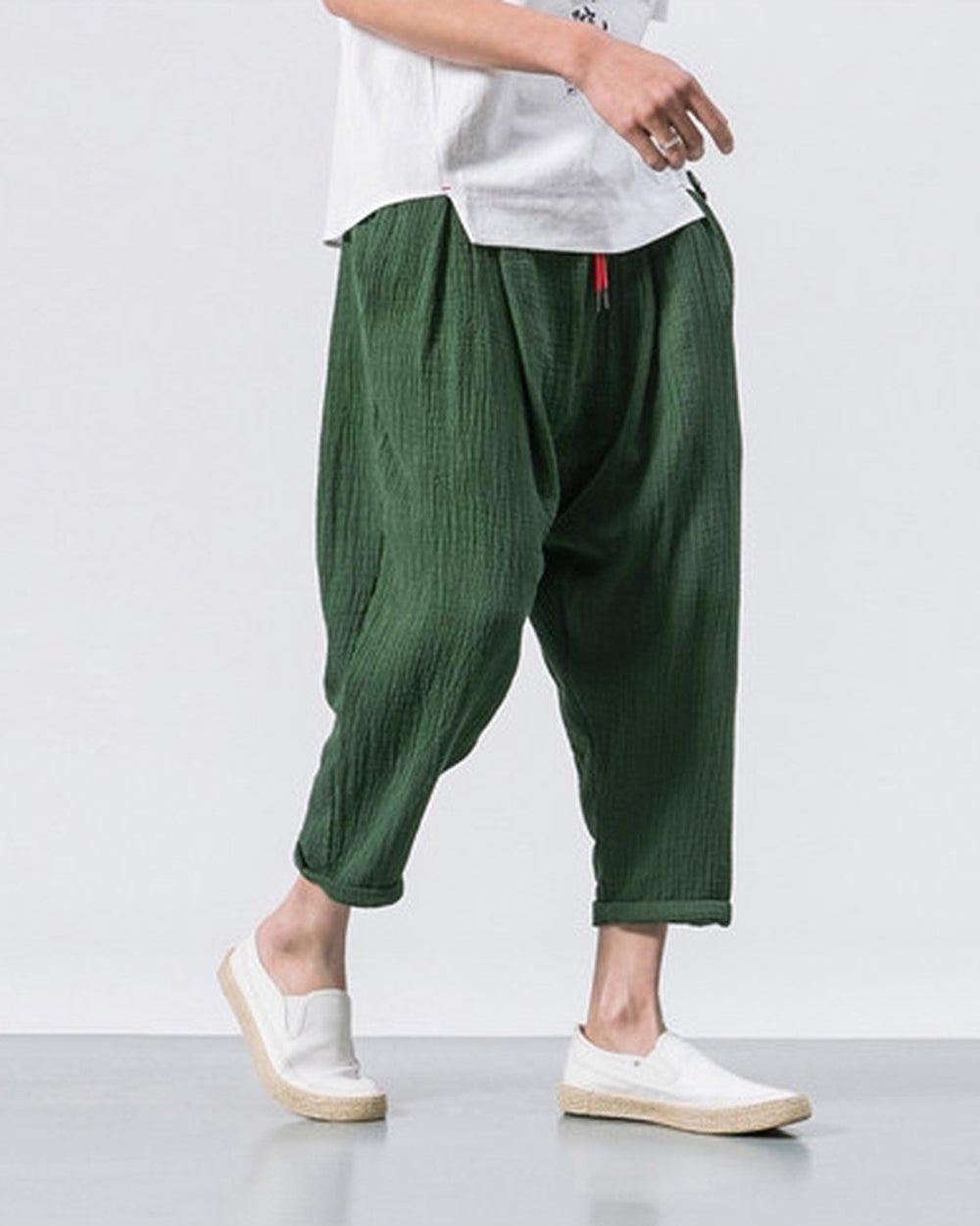 Forest green crinkled harem pants in motion, showing the low crotch and the rolled cuffs