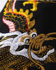 Close view of the dragon's head and white clouds embroidered near the cuff of the black sweatshirt sleeve