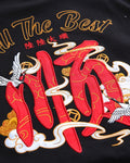 Close-up of the red character, cranes and gold-thread script embroidered on the back of the black T-shirt