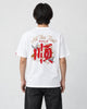 Model seen from behind in the white T-shirt with a large red embroidered character, white cranes and gold-thread script
