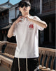 Man in the white T-shirt from the front, with the small red and gold emblem on the left chest