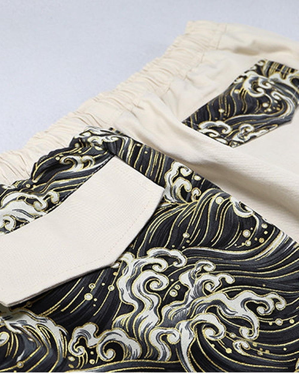 Close-up of the back flap pockets, one in cream cloth on the wave print and one in wave print on the cream