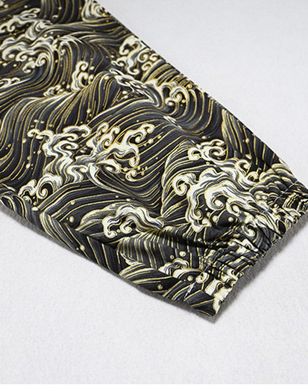 Close-up of the gathered elastic cuff on the wave-print leg