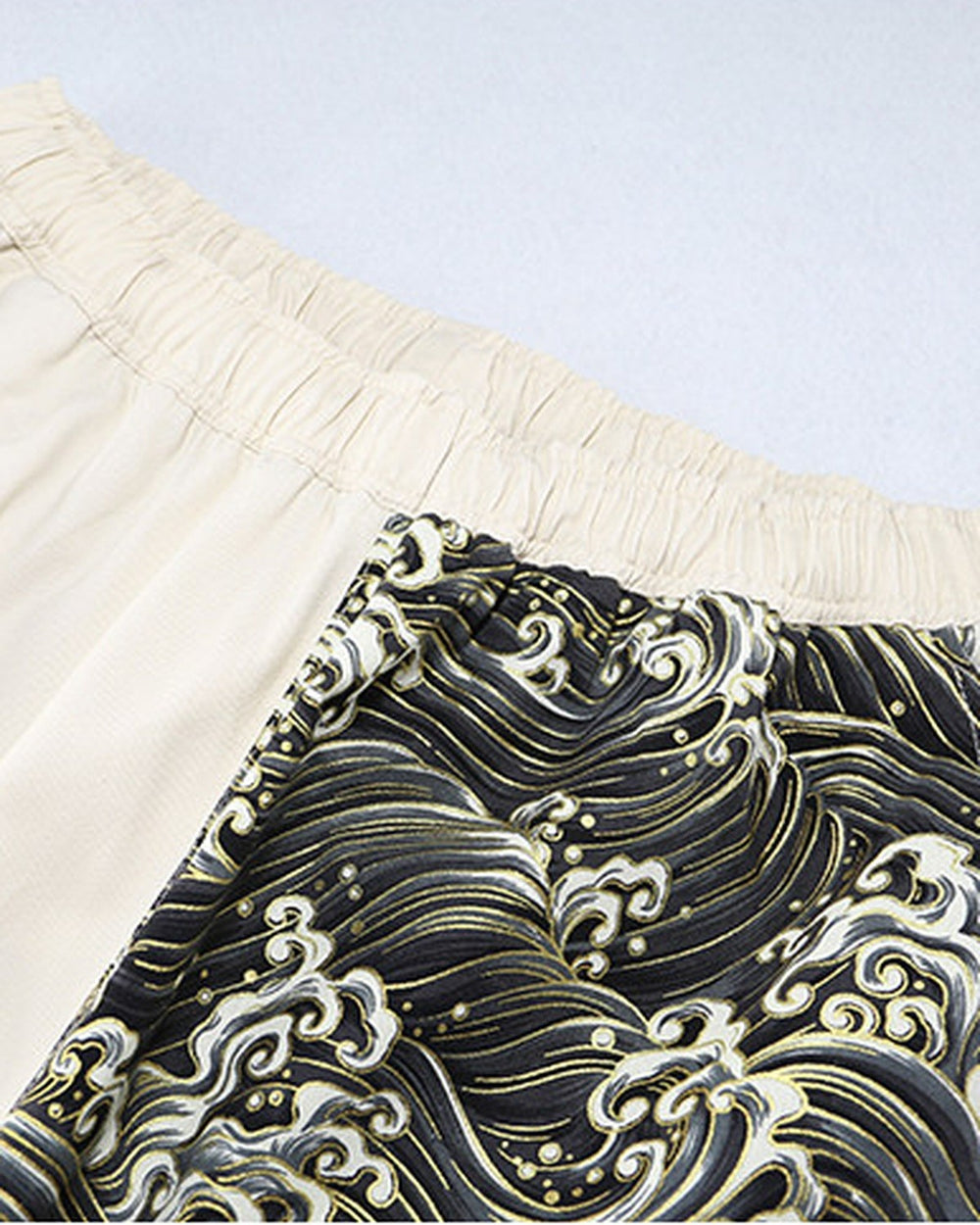 Close-up of the elastic waistband where the cream leg meets the wave-print leg