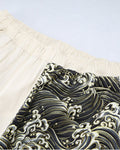 Close-up of the elastic waistband where the cream leg meets the wave-print leg