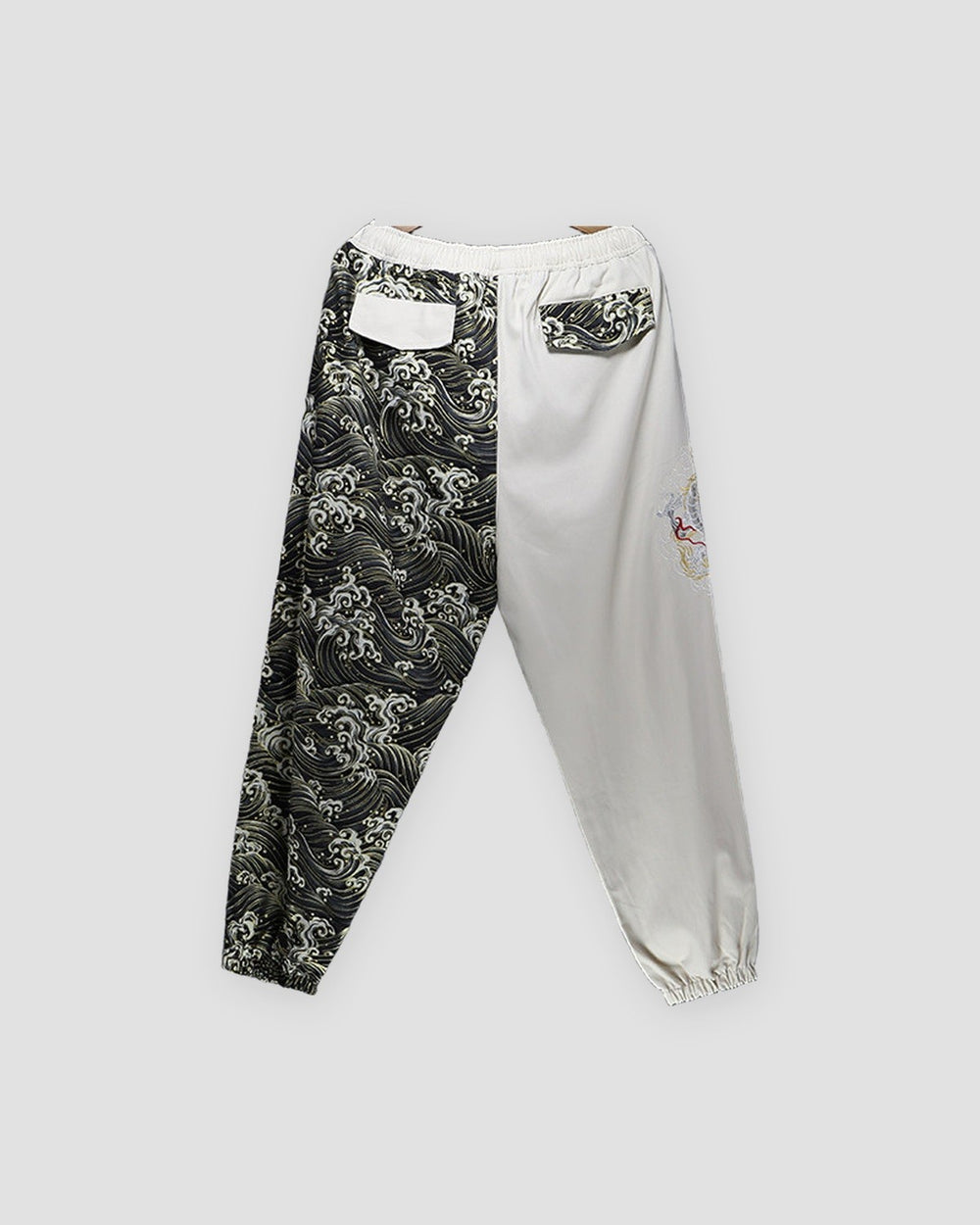 Back of the cream and wave-print jogger pants, with a flap pocket on each leg cut from the other leg's cloth