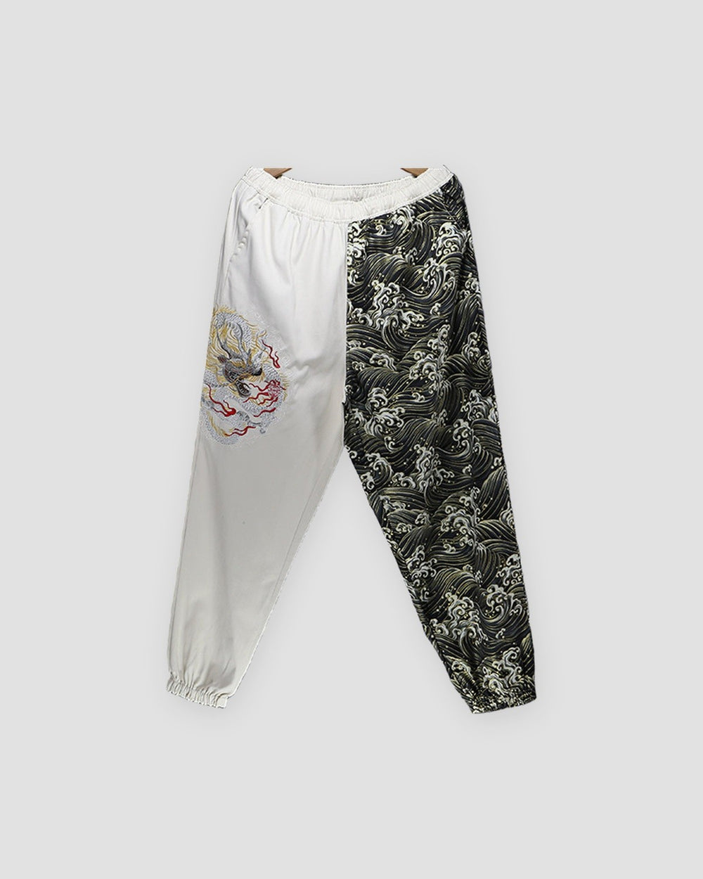 Cream and wave-print jogger pants with an embroidered dragon on the cream leg, front view
