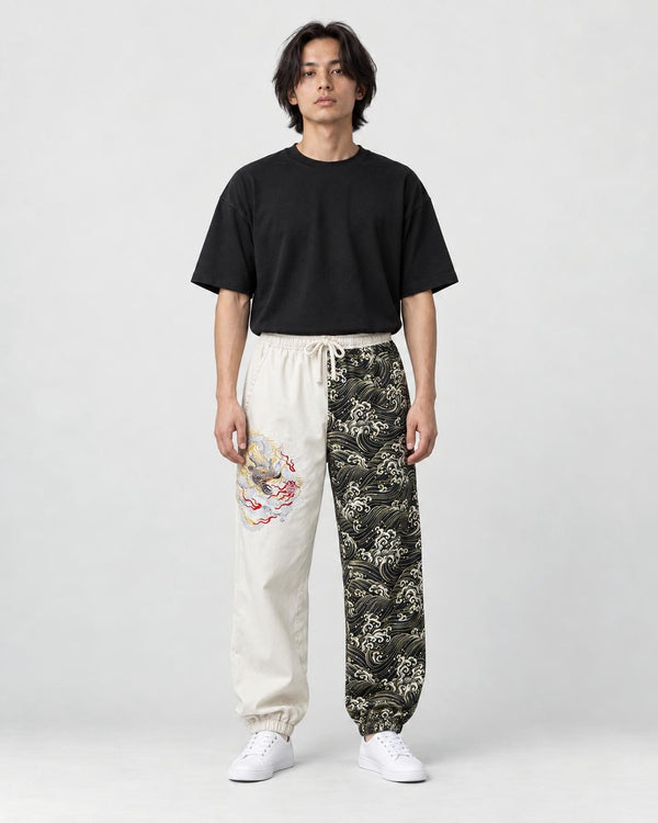 Model wearing the cream and wave-print jogger pants with a black tee and white sneakers, front view