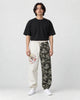 Model wearing the cream and wave-print jogger pants with a black tee and white sneakers, front view