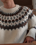 Close view of the round yoke in brown, charcoal and blue-gray on the cream sweater