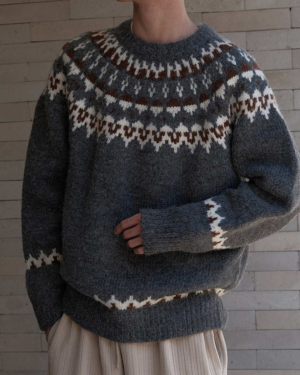 Charcoal gray fair-isle sweater with a cream and brown zigzag yoke, torso view
