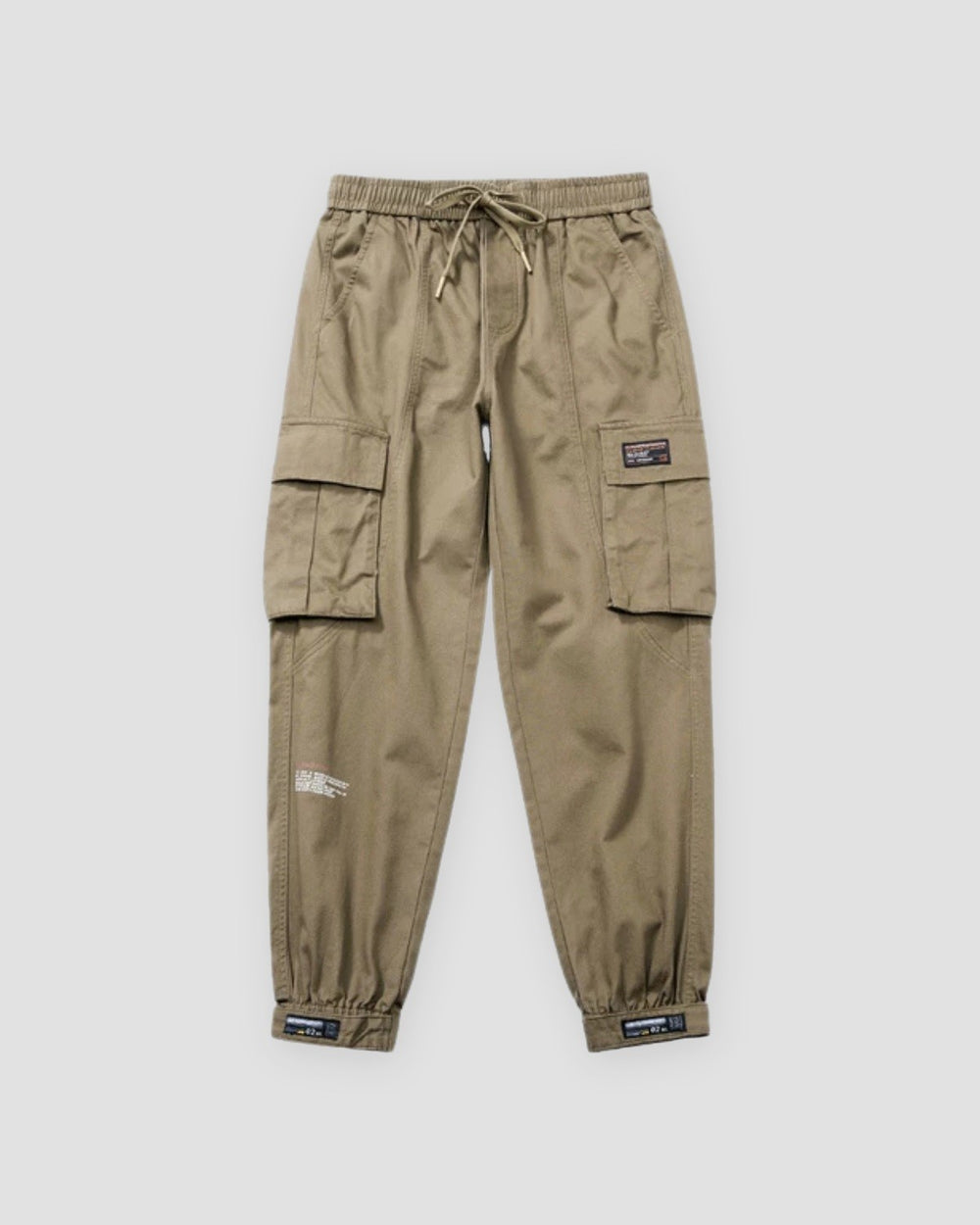 Khaki cargo joggers with flap pockets, a woven label and strap tabs at the ankles, flat view