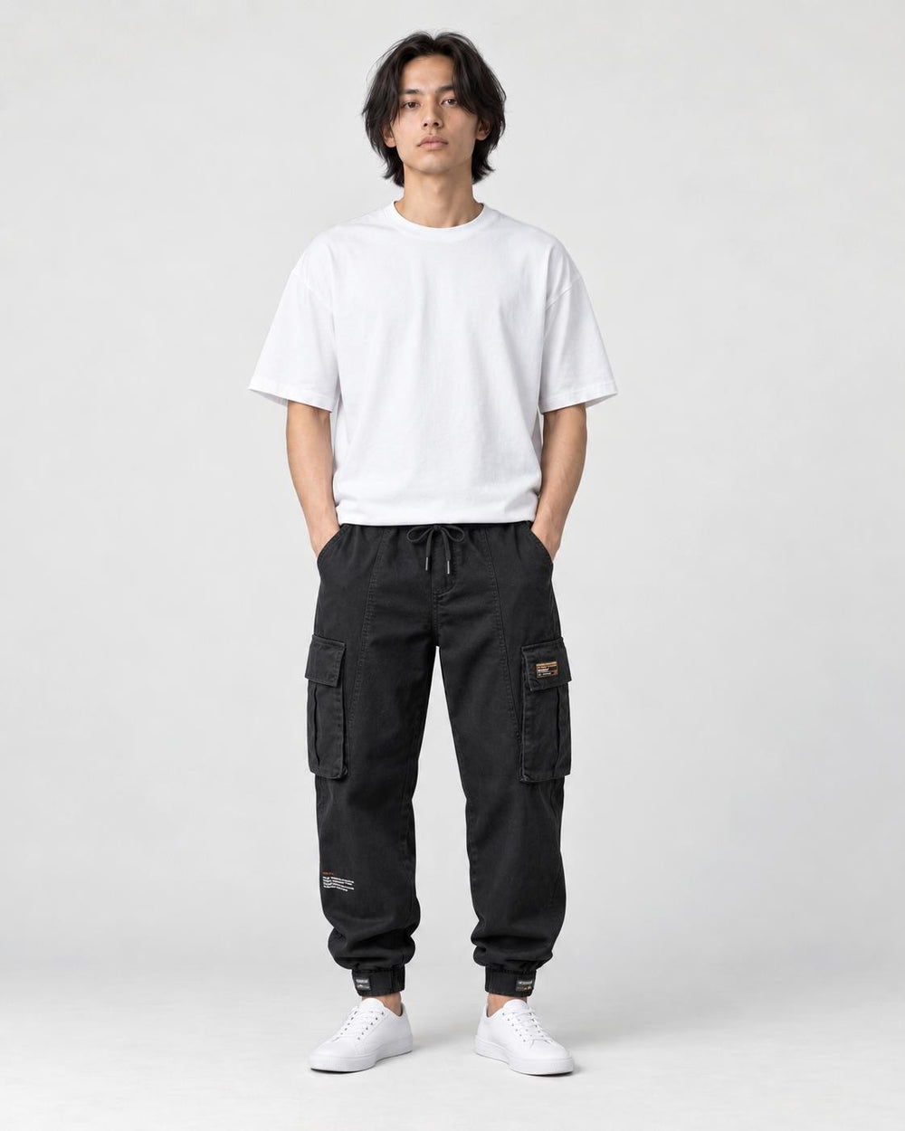 Model wearing the black cargo joggers with a white tee and white sneakers, front view