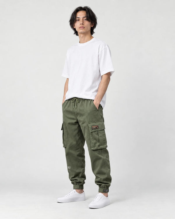 Model wearing the army green cargo joggers with a white tee and white sneakers, three-quarter view